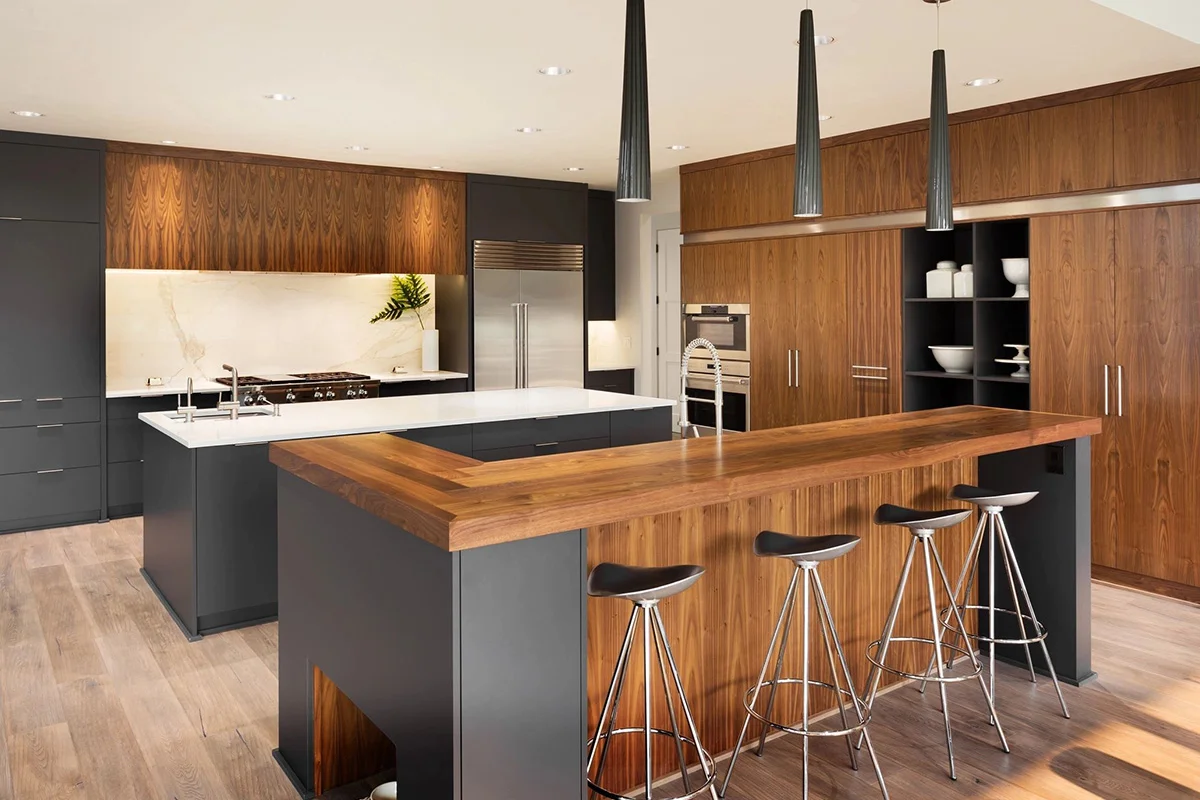 A kitchen with wooden counter tops and black stools.