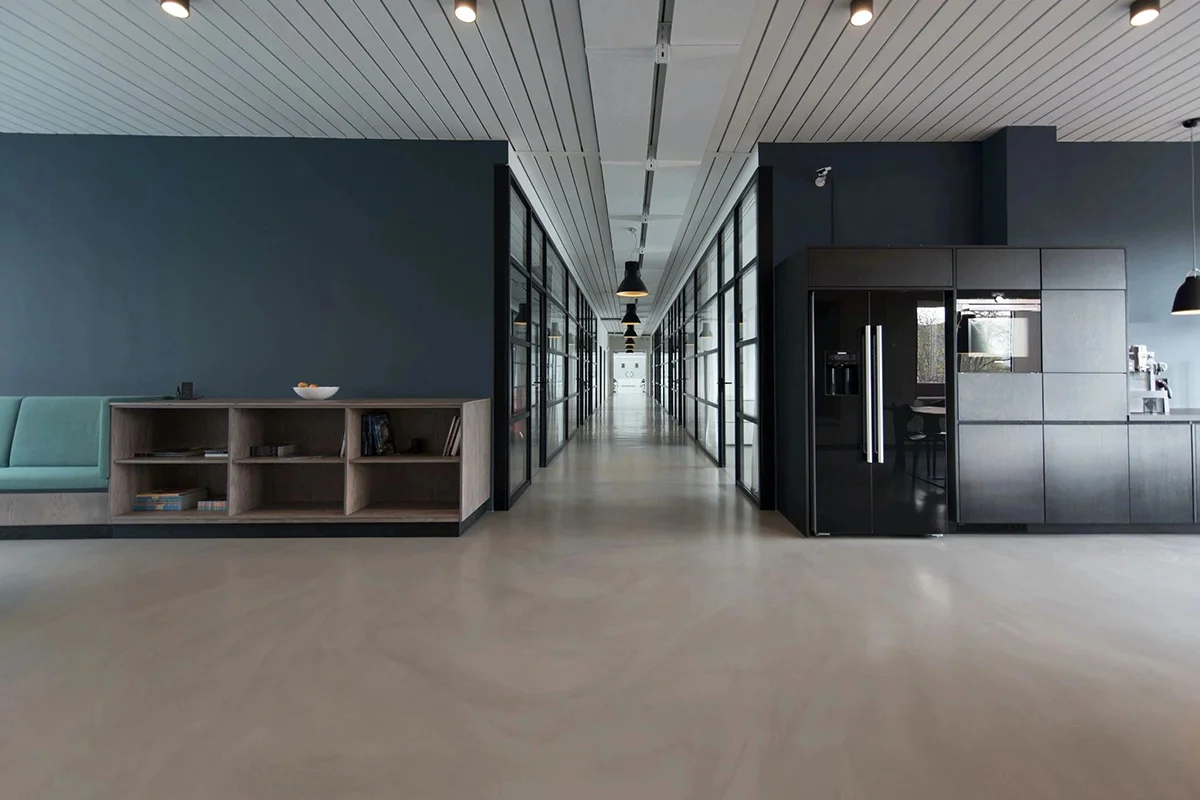 A long hallway with two refrigerators and shelves.